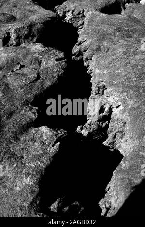 Immagine verticale in scala di grigi di formazioni rocciose, ideale per a. sfondo freddo Foto Stock