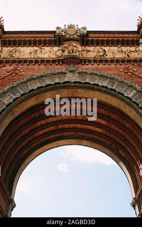 Immagine verticale ad angolo basso di un arco in cemento con bella sculture Foto Stock