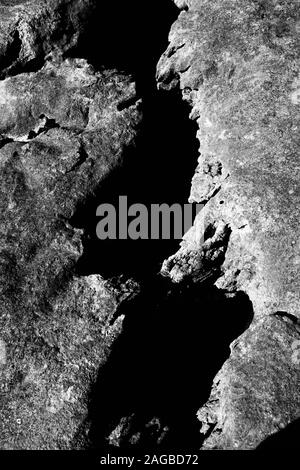 Immagine verticale in scala di grigi di formazioni rocciose, ideale per a. sfondo freddo Foto Stock