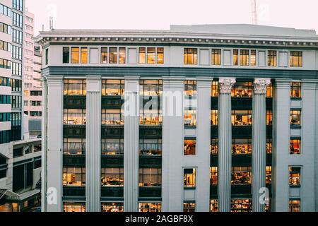Vista completa di un moderno edificio bianco con colonne e. incisioni su di loro con finestre e luci Foto Stock