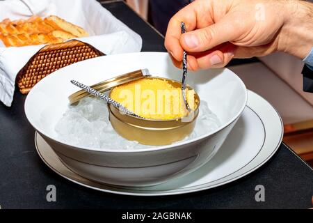 Persona che mangia caviale bianco da raro storione albino a reception Foto Stock