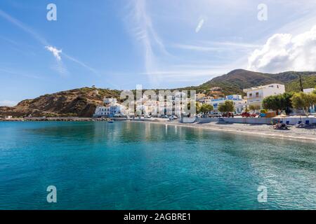 Scenario di mare e una spiaggia circondata da montagne e. Edifici sotto un cielo blu in Karpathos Foto Stock