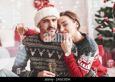 Insieme a vacanze. Felici i giovani si siede in camera con decorazioni di Natale Foto Stock