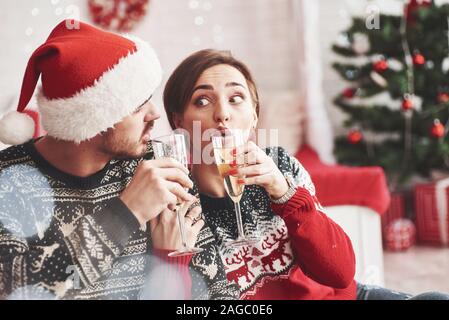 Funny ragazza. Felici i giovani si siede in camera con decorazioni di Natale Foto Stock