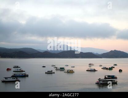 Barche su un lago di sunrise, montagne in background (Dique Cabra Corral, Salta, Argentina) Foto Stock