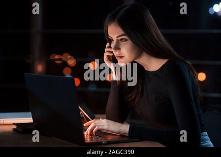 Ho solo bisogno di fare una relazione. Attraente brunette imprenditrice funziona solo in ufficio in notturna Foto Stock