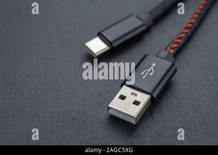 Tipo C cavo USB con cavo contro uno sfondo scuro. Foto Stock