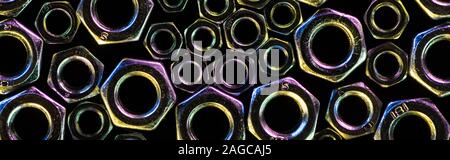 Panoramica di sparse in grandi e piccoli dadi in metallo isolato su nero Foto Stock