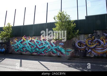 Colorati murali & i graffiti sulla parete di pace,o linea di pace, che corre lungo Cupar modo a Belfast. È una delle tante barriere di separazione in N.Irlanda Foto Stock