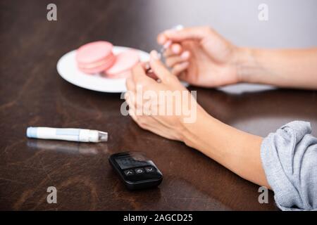 Vista ritagliata della donna tenendo la siringa vicino a dessert Foto Stock