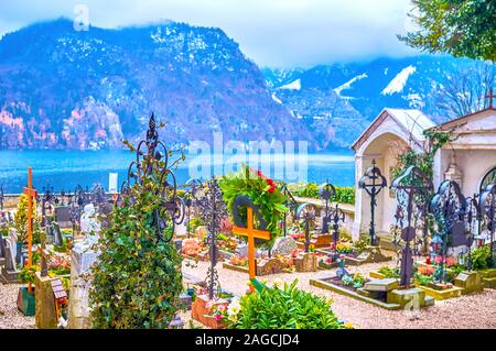 Il piccolo cimitero sul territorio della chiesa parrocchiale con righe di tombe e una straordinaria vista sul Traunsee (lago Traun) e montagne, Traunkirchen Foto Stock