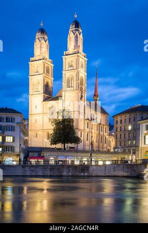 Chiesa Grossmuenster al crepuscolo, di fronte fiume Limmat, Zurigo, Svizzera Foto Stock