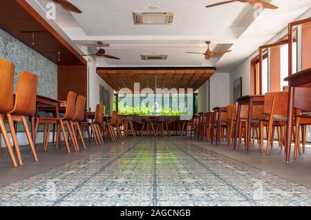 Foto ad angolo basso di un caffè con sedie in legno e. Tavoli a Phnom Penh in Cambogia Foto Stock