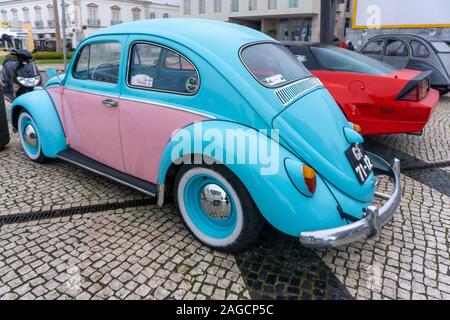 Faro, Portogallo. Una vettura di Volkswagen Beetle ricondizionata, colorata in blu e rosa, parcheggiata su ciottoli a Faro, in Portogallo Foto Stock