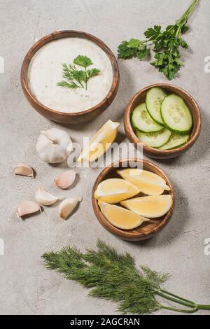 Greco tradizionale salsa tzatziki da yogurt, cetriolo con limone e aglio su sfondo di pietra Foto Stock