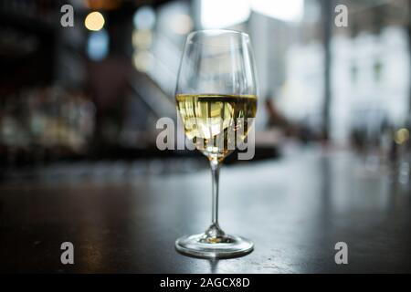 Bicchiere di champagne su una superficie nera con l'edificio colonne riflettenti in esso Foto Stock