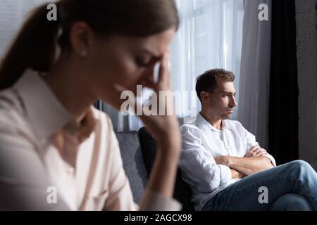 Messa a fuoco selettiva di donna triste e pensieroso uomo sul divano Foto Stock