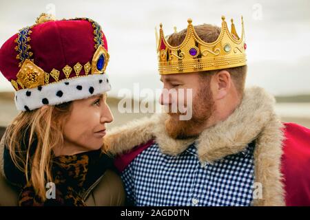 Ritratto di metà di uomo adulto che indossa la corona mentre guardando la sua moglie. Foto Stock