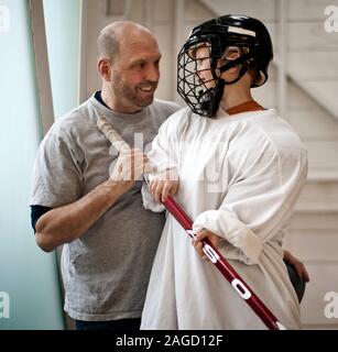 Ritratto di giovane giocatore di hockey in piedi con il suo papà, Foto Stock