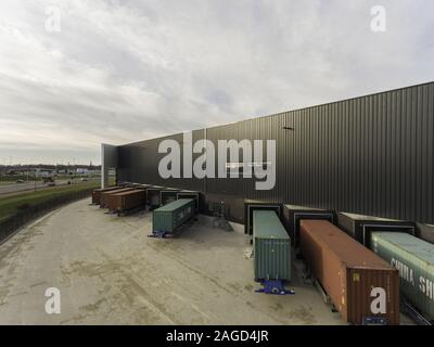 OOSTERHOUT, Paesi Bassi - 06 DIC 2019: Rimorchi con contenitori davanti ad un magazzino. Pronto per lo scarico delle merci. Foto Stock