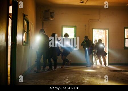 Il gruppo di funzionari di polizia all'interno di un edificio durante un esercizio al training facility. Foto Stock