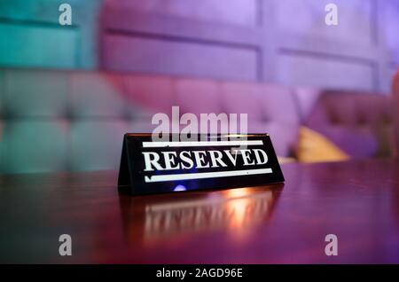 Riservati sign in piedi sul tavolo di legno in bar Foto Stock