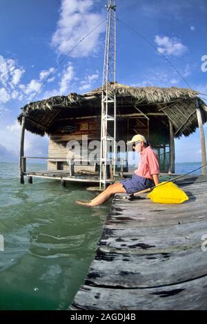 Pescatore femmina si prende una pausa dalla pesca su un dock in Messico Foto Stock