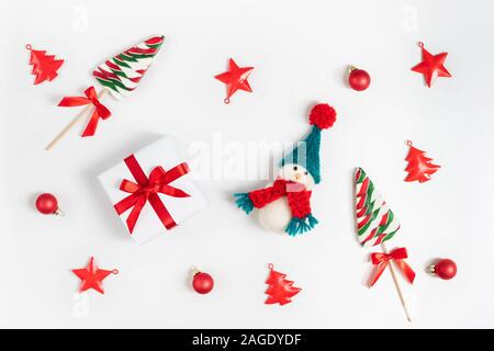 Composizione di natale con pupazzo di neve, lecca lecca e decorazioni di Natale. Felice anno nuovo. Concetto di inverno. Biglietto di auguri. Vista superiore, piatto laici. Foto Stock