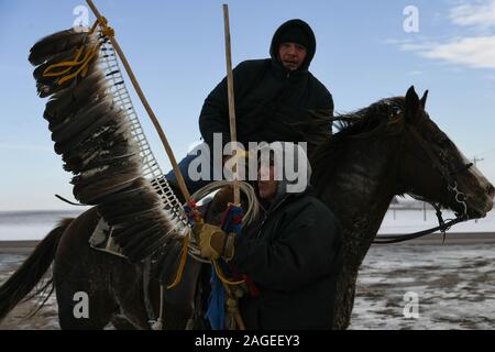 Pipestone, Minnesota, Stati Uniti d'America. Xviii Dicembre, 2019. WILFRED KEEBLE prende la bandiera delle piume da un Dakota rider durante una sosta a sud di confine Dakota-Minnesota mercoledì, l'ottavo giorno e 167 miglio di un 325-mile Dakota 38 2 Memorial Ride a Mankato, Minnesota, sito del più grande esecuzione di massa nella storia degli Stati Uniti. Il presidente Abraham Lincoln ha ordinato la sospensione del 38 indiani Dakota ""e successive, due capi ""a seguito della loro sollevazione contro il governo degli Stati Uniti dopo gli Stati Uniti Credito: ZUMA Press, Inc./Alamy Live News Foto Stock