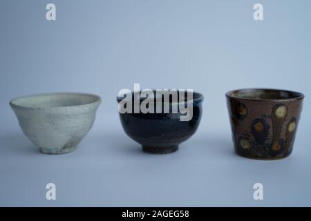 Primo piano di tre diverse ciotole in ceramica d'epoca con un sfondo grigio Foto Stock