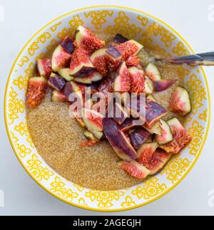 Senza glutine di porridge di amaranto per la prima colazione con i fichi in una ciotola gialla vista superiore Foto Stock