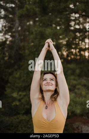 La donna a praticare yoga in foresta Foto Stock