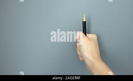 Mano in presa su una penna a sfera e averlo montante, con copia spazio sulla sinistra. Foto Stock