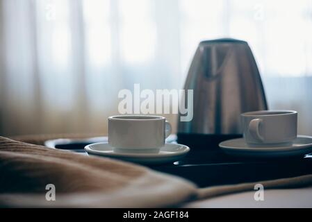 La colazione del mattino con caffè nero in camera da letto. Due tazze di caffè sul letto decorato con petali di rosa in hotel di lusso in camera da letto. Foto Stock