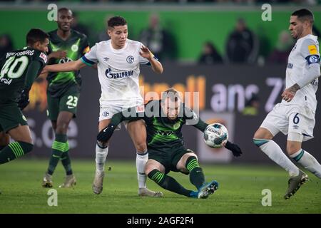 Wolfsburg, Germania. Xviii Dicembre, 2019. Calcio: Bundesliga, VfL Wolfsburg - FC Schalke 04, xvi giornata in Volkswagen Arena. Wolfsburg è Massimiliano Arnold (secondo da destra) gioca contro Schalke's Harit ammina (terzo da destra). Credito: Swen Pförtner/dpa - NOTA IMPORTANTE: In conformità con i requisiti del DFL Deutsche Fußball Liga o la DFB Deutscher Fußball-Bund, è vietato utilizzare o hanno utilizzato fotografie scattate allo stadio e/o la partita in forma di sequenza di immagini e/o video-come sequenze di foto./dpa/Alamy Live News Foto Stock