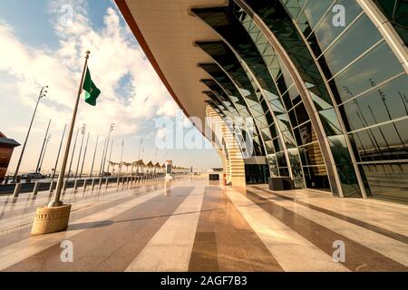 Arabia bandiera sventola al vento nella parte anteriore del nuovissimo terminal 1 presso il King Abdulaziz International Airport (JED) a Jeddah, Arabia Saudita Foto Stock