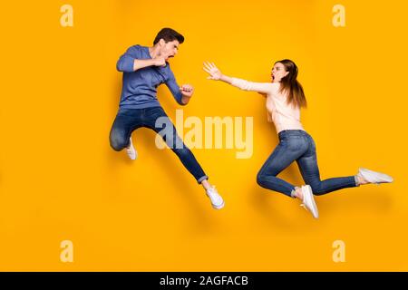 Foto completa del corpo di due ninja donna uomo hanno lotta battaglia jump kick gambe mani sentire crazy usura rosa maglione blu jeans denim sneakers isolate su Foto Stock