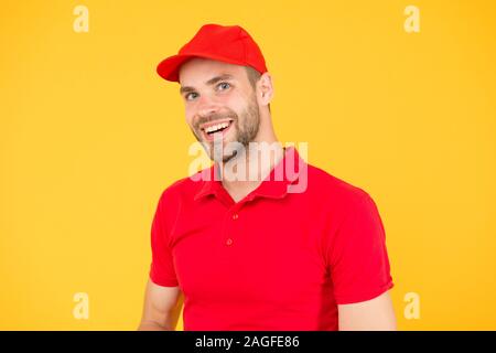 Amichevole negozio assistente. food order deliveryman. cassiere vacante. Affitto shop store lavoratore. happy guy. concessionario parete gialla. Venditore cassiere carriera. l uomo servizio consegna in rosso tshirt e tappo. Foto Stock