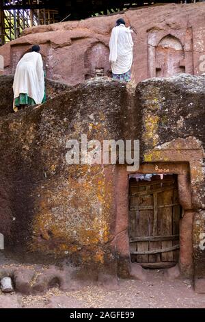 Etiopia, Amhara Region, Lalibela, Arbatu Ensessa, Biblia Chirkos chiesa, devoti parete di arrampicata a pregare in mattina presto Foto Stock