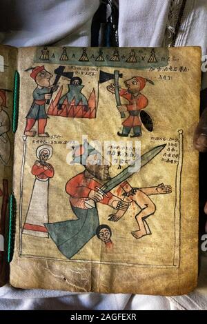 Etiopia, Amhara Region, Lalibela, Arbatu Ensessa, Biblia Chirkos, antiche rocce scavate chiesa, sacerdote mostra 800 anno-vecchio vangelo illuminato mostra vai Foto Stock