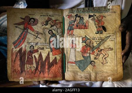 Etiopia, Amhara Region, Lalibela, Arbatu Ensessa, Biblia Chirkos, antiche rocce scavate chiesa, sacerdote mostra 800 anno-vecchio vangelo illuminato mostra vai Foto Stock