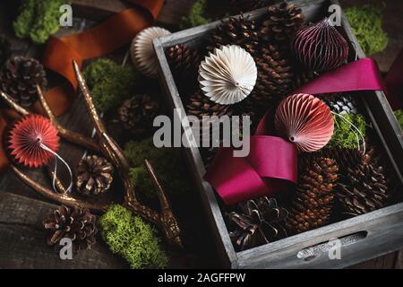 Ornamenti naturali per la decorazione domestica nel tempo di Natale - coni, muschio, ornamenti di carta Foto Stock