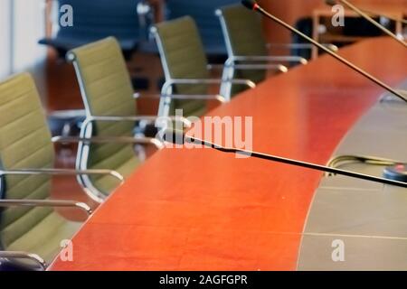 Il microfono su un tavolo in legno e sedie vuote in una sala riunioni. Il concetto di business Foto Stock