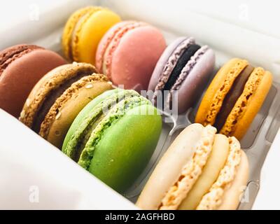 Un gruppo di macaron colorati impilati in una confezione di plastica. Meringa-basato dessert Foto Stock