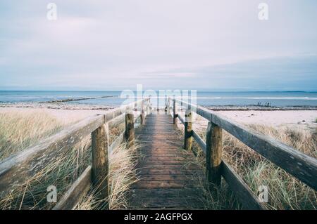 Splendido scenario di un sentiero in legno che conduce alla spiaggia per una giornata rilassante Foto Stock