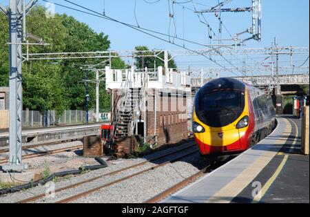 Una Vergine Pendolino non identificata passa Lichfield Trent Valley Signal Box visto parzialmente smantellato durante i lavori di aggiornamento della linea principale della costa occidentale. Foto Stock