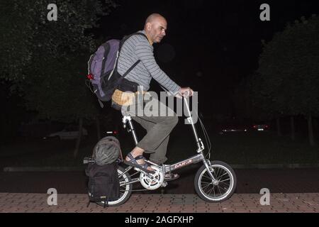 Uomo maturo su una ripiegata bicicletta Dahon Foto Stock