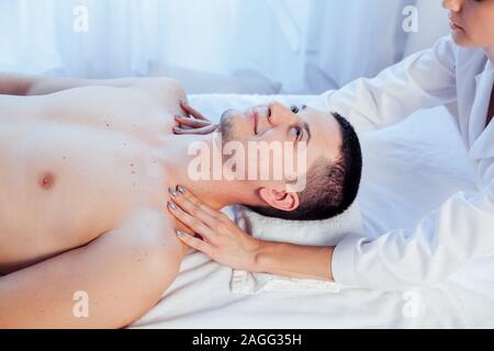 Medico cosmetologo facendo il massaggio del viso uomini trattamenti termali Foto Stock