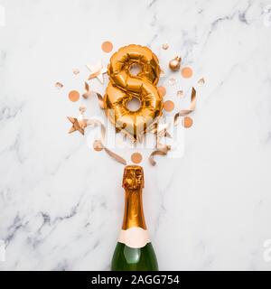 Bottiglia di Champagne con numero gold 8 palloncino. La minima parte anniversario concetto Foto Stock