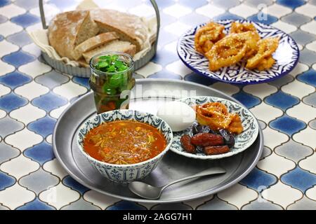 Il Ramadan marocchino iftar pasto, harira zuppa, chebakia, date, tè alla menta e khubz Foto Stock